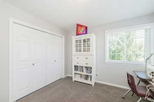 Home office featuring dark carpet and baseboards