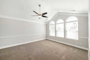 Primary bedroom with lofted ceiling, decorative molding, and ceiling fan