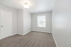 Unfurnished room featuring carpet floors and baseboards