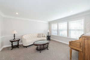 Carpeted living room featuring ornamental molding and recessed lighting