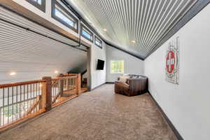 Living area featuring carpet flooring, recessed lighting, and high vaulted ceiling