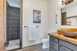 Full bathroom featuring a shower stall, vanity, and wood tiled floors