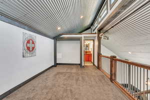 Hall featuring lofted ceiling and carpet floors
