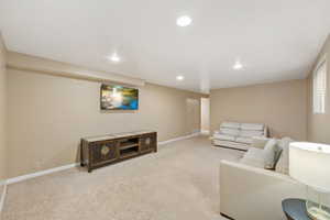 Living area with recessed lighting and carpet floors