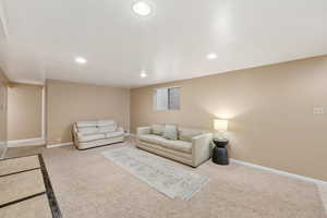 Living area with recessed lighting and light colored carpet