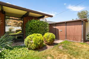 View of green lawn featuring an outbuilding