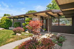 View of front of house featuring stone siding and a front yard