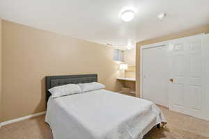 Bedroom featuring light colored carpet and a closet