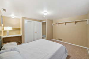 Carpeted bedroom featuring baseboards and a closet