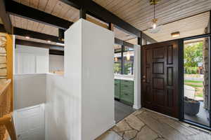 Entryway featuring baseboards and a wooden ceiling with exposed beams