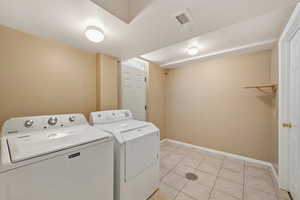 Washroom featuring light tile patterned floors and washer and dryer