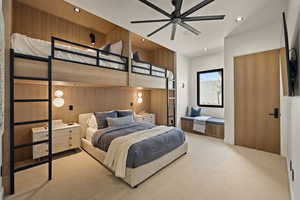 Carpeted bedroom with ceiling fan, wooden walls, and recessed lighting