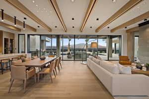 Dining area with a mountain view, beam ceiling, plenty of natural light, light wood-style floors, and recessed lighting