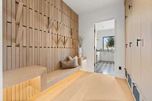 Mudroom featuring light wood finished floors and baseboards