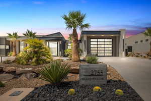 Modern home with driveway, an attached garage, and stucco siding