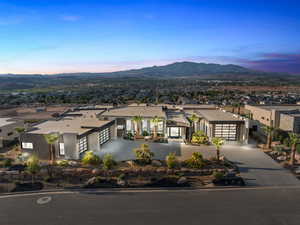 View of front of home with concrete driveway, a mountain view, and stucco siding