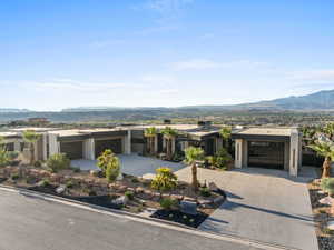 View of front facade featuring a mountain view, driveway, stucco siding, and a garage