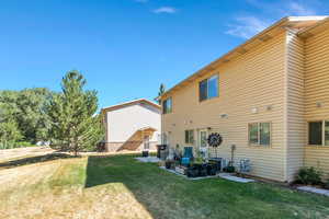 Rear view of property featuring a lawn and a patio area