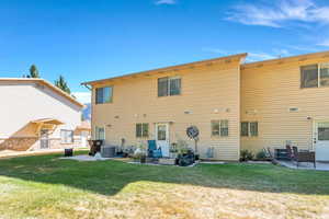 Rear view of property featuring a patio and a lawn