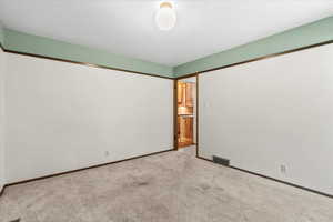 Empty room with carpet and baseboards