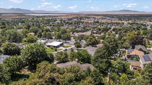 Aerial view of property and surrounding area with mountains and nearby suburban area