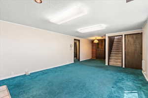 Unfurnished bedroom featuring carpet floors, a textured ceiling, and two closets
