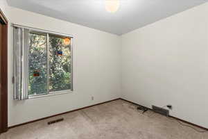 Empty room featuring carpet and baseboards