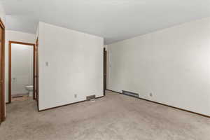 Carpeted empty room with baseboards