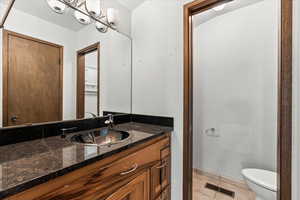 Bathroom featuring light tile patterned flooring, vanity, and a chandelier