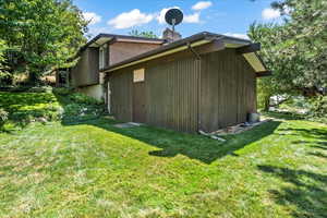 View of home's exterior featuring a yard and a chimney