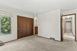 Unfurnished bedroom with carpet flooring and a closet