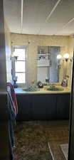 Bathroom featuring a textured ceiling and double vanity