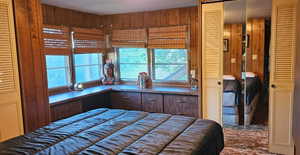 Bedroom featuring a closet and wooden walls