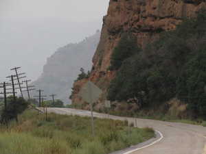 View of asphalt road with traffic signs and a mountain view