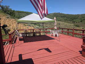 Deck with outdoor dining area and a wooded view
