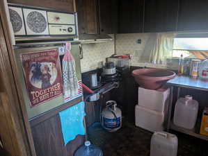 Kitchen with wallpapered walls and dark brown cabinetry