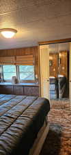 Bedroom featuring wooden walls and a closet