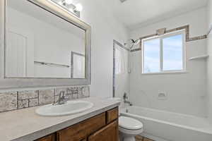 Bathroom with shower / washtub combination, vanity, decorative backsplash, and a textured ceiling