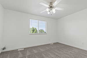 Unfurnished room featuring carpet floors and ceiling fan