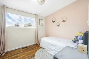 Bedroom with dark wood-style floors and baseboards
