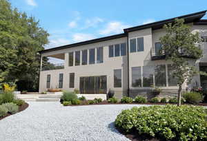 Rear view of property featuring a balcony and stucco siding