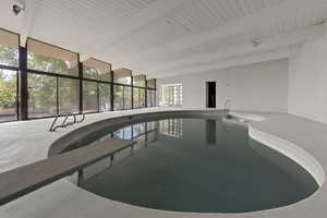 View of pool with a sunroom and a jacuzzi