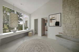 Full bath featuring high vaulted ceiling, a freestanding bath, and tile patterned flooring