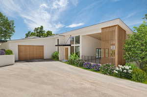Contemporary home with stucco siding, an attached garage, and driveway