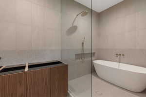 Full bathroom featuring tile walls, a walk in shower, and a soaking tub