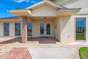 View of exterior entry featuring a patio, stucco siding, and french doors