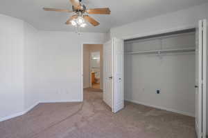Unfurnished bedroom with light carpet, a closet, and ceiling fan