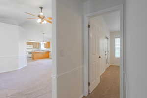 Hall featuring light colored carpet and lofted ceiling