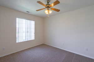 Empty room with carpet floors and ceiling fan