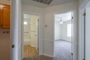 Corridor featuring light colored carpet